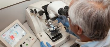 Mężczyzna pracujący w laboratorium nad mikroskopem.