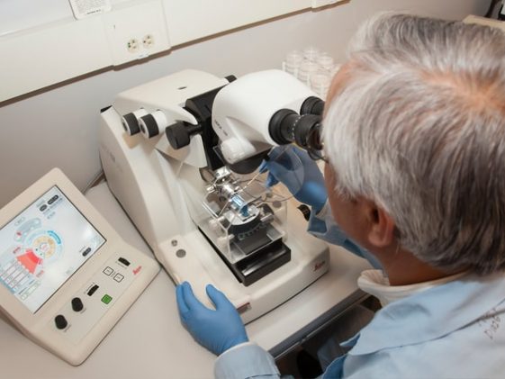 Mężczyzna pracujący w laboratorium nad mikroskopem.