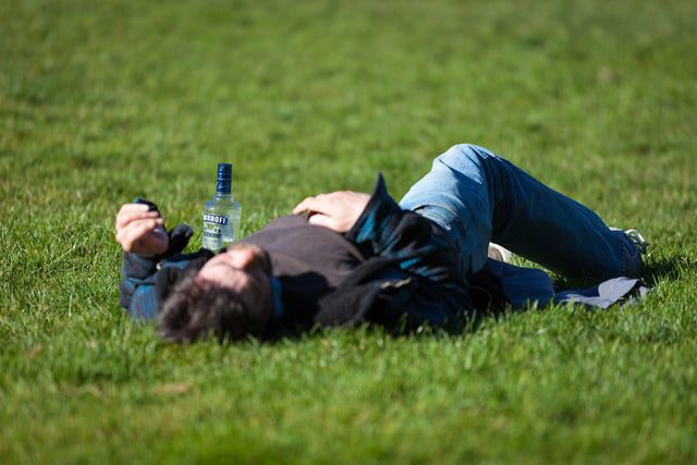 Mężczyzna śpiący na trawie. 