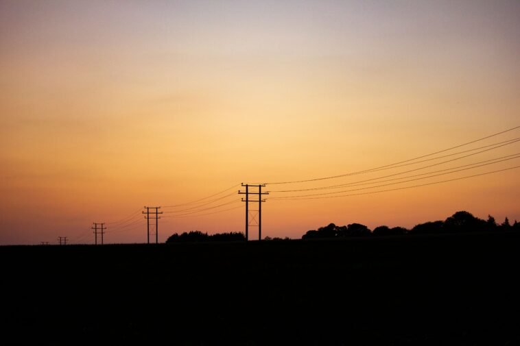 PGE infolinia — numer, awarie prądu i godziny (2026) Linie energetyczne i słupy o zachodzie słońca - infolinia PGE