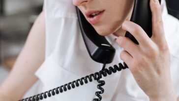 Osoba trzymająca smartfon podczas rozmowy z infolinią T-Mobile