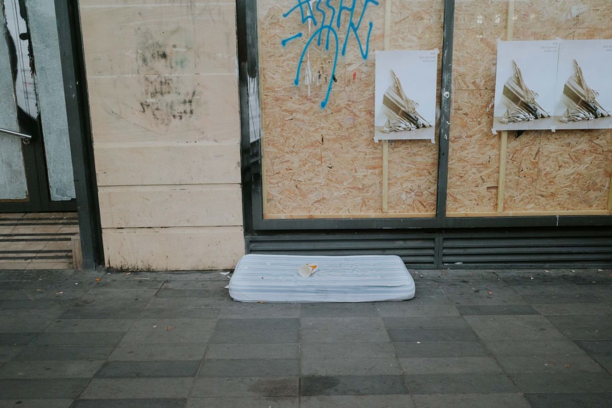 Stary materac porzucony na chodniku, przykład nielegalnego pozbycia się odpadu wielkogabarytowego