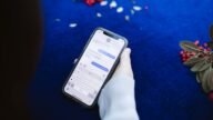 Dłoń trzymająca smartfon z otwartą wiadomością SMS