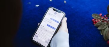 Dłoń trzymająca smartfon z otwartą wiadomością SMS