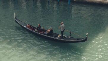 Turyści płynący gondolą po Canal Grande w Wenecji