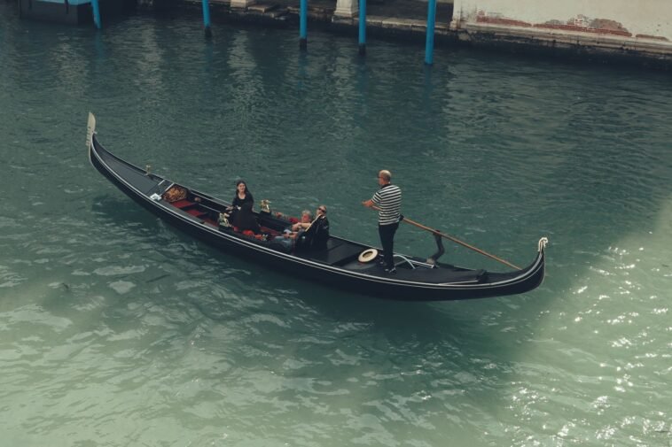 Turyści płynący gondolą po Canal Grande w Wenecji