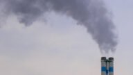 Dym unoszący się z komina domu jednorodzinnego w sezonie grzewczym
