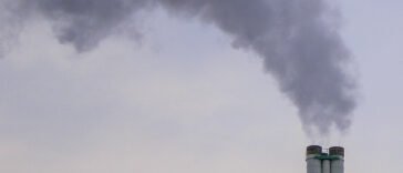 Dym unoszący się z komina domu jednorodzinnego w sezonie grzewczym