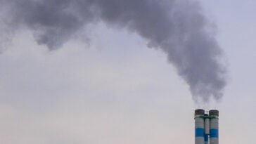 Dym unoszący się z komina domu jednorodzinnego w sezonie grzewczym