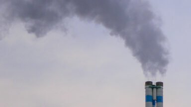 Dym unoszący się z komina domu jednorodzinnego w sezonie grzewczym