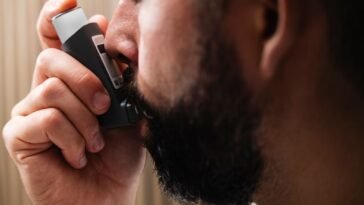 Mężczyzna korzystający z inhalatora, podstawowa forma leczenia astmy oskrzelowej