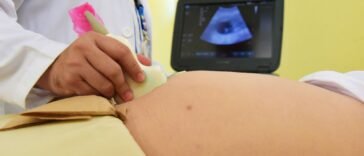 Lekarz bada jamę brzuszną pacjenta podczas wizyty w gabinecie