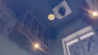 Biała czujka dymu przykręcona do sufitu w mieszkaniu