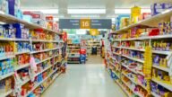 Alejka w sklepie spożywczym z półkami pełnymi paczkowanych produktów