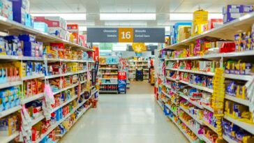 Alejka w sklepie spożywczym z półkami pełnymi paczkowanych produktów