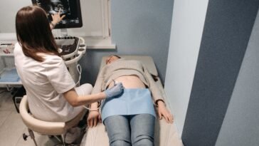 Lekarz wykonuje badanie USG tarczycy u pacjentki