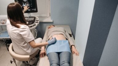 Lekarz wykonuje badanie USG tarczycy u pacjentki