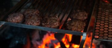 Kotlety burgerowe z mięsa mielonego smażące się na ruszcie grilla
