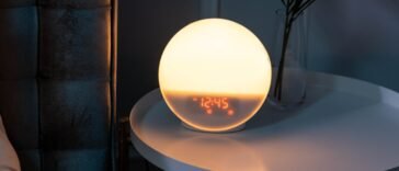 Budzik stojący na szafce nocnej przy łóżku, symbol zmiany czasu na zimowy