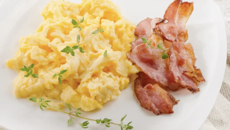 Keto śniadanie: przepis i 11 pomysłów z kaloriami i makro Keto śniadanie: jajecznica z chrupiącym boczkiem i tymiankiem na białym talerzu