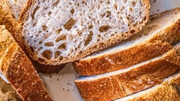 Pokrojony bochenek chleba na zakwasie z widocznym miękiszem