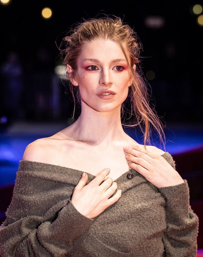 Hunter Schafer Hunter Schafer z rudymi włosami w szarym swetrze z odkrytymi ramionami