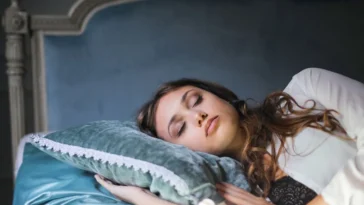 Kobieta śpi spokojnie na poduszce, jak się dobrze wyspać i obudzić wypoczętym