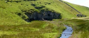 Potok Mossdale Beck znika pod wapiennym urwiskiem Mossdale Scar, gdzie zaczyna się jaskinia Mossdale Caverns