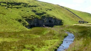 Potok Mossdale Beck znika pod wapiennym urwiskiem Mossdale Scar, gdzie zaczyna się jaskinia Mossdale Caverns