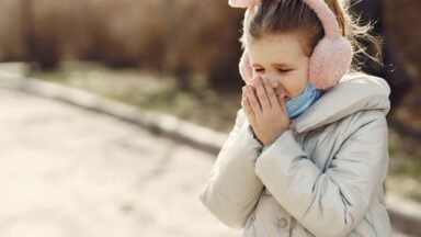 Młoda kobieta kicha, odruch kichania na słońce