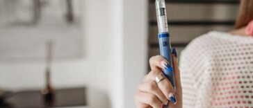 Kobieta trzyma w dłoni pen z lekiem do wstrzykiwań podskórnych