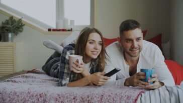 Para ogląda film w domu podczas wieczoru filmowego