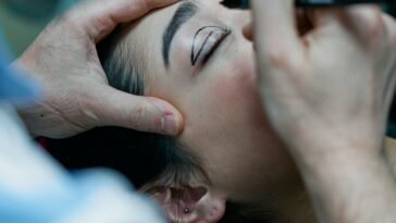 Chirurg zaznacza markerem linię cięcia na powiece pacjentki przed blefaroplastyką