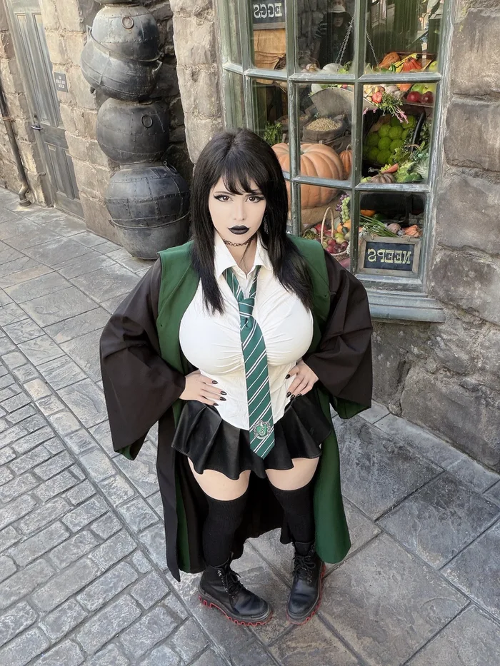 Pinkchyu w cosplayu ucznia Slytherinu w szacie z zielonym krawatem