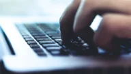 Osoba pisząca na klawiaturze laptopa podczas zakupów w internecie