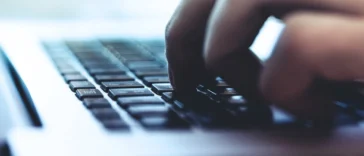 Osoba pisząca na klawiaturze laptopa podczas zakupów w internecie