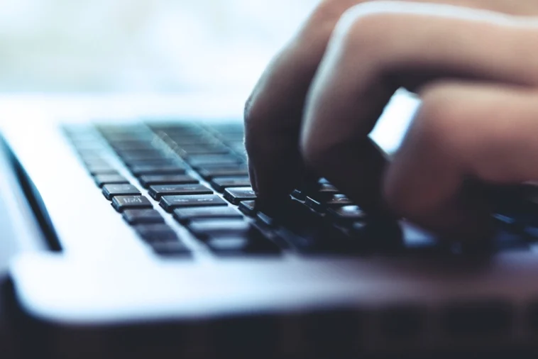 Osoba pisząca na klawiaturze laptopa podczas zakupów w internecie