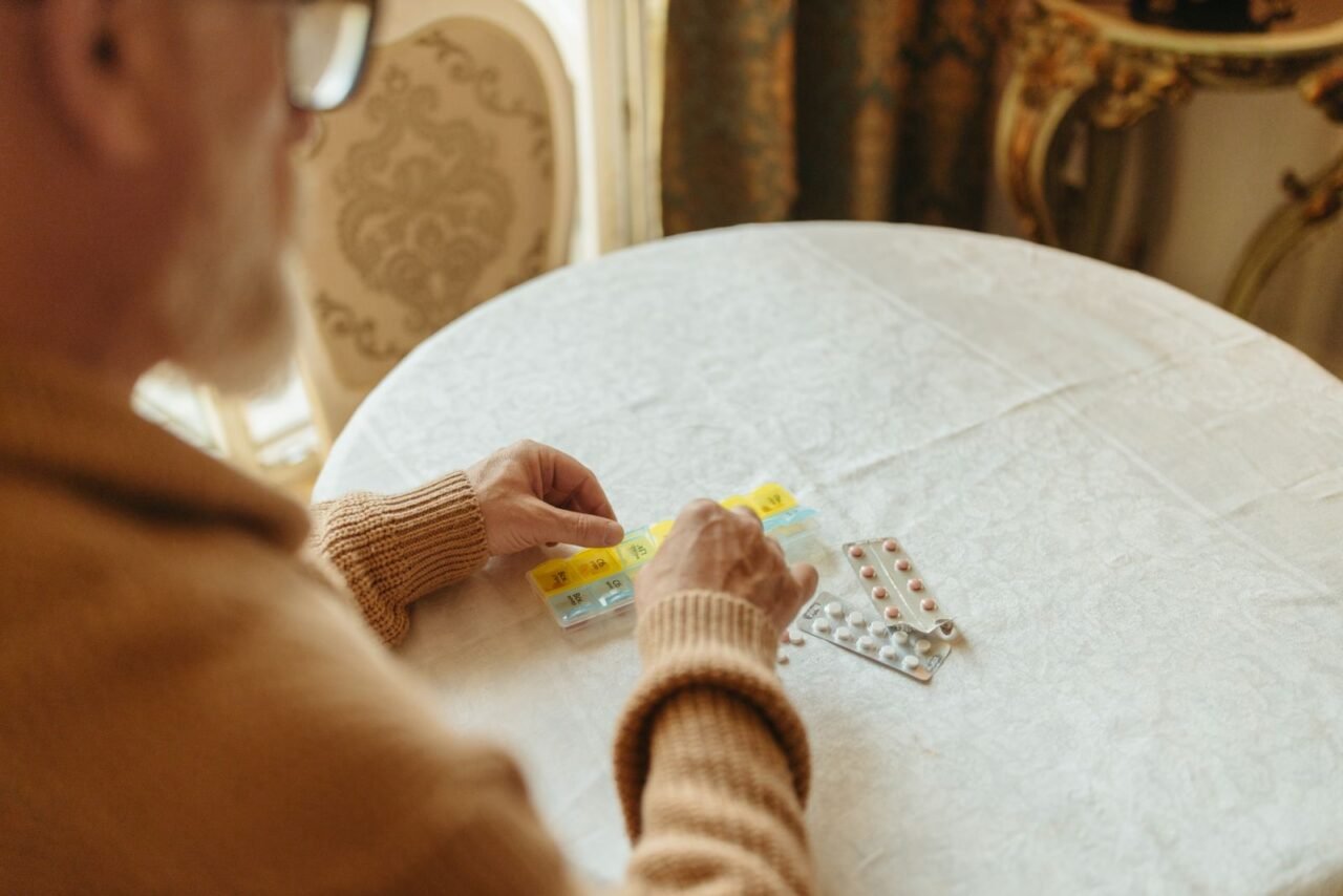 Bolą cię mięśnie i winisz tabletki na cholesterol. W badaniach z placebo bolało prawie tak samo często Starszy mężczyzna przegląda blistry z tabletkami na cholesterol przy stole