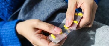 Dłoń trzymająca blister z tabletkami, krótka kuracja sterydami doustnymi